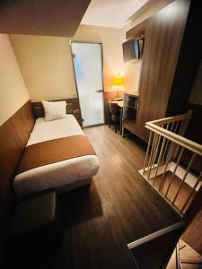 Una habitación de hotel con una cama, un escritorio y una escalera. en OZO Hotels Cordial Amsterdam, en Ámsterdam
