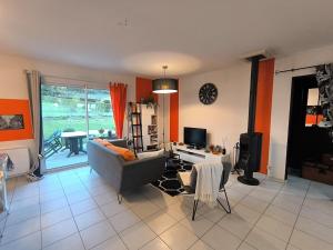 a living room with a couch and a table and a tv at La Parenthèse colorée - spacieux - 12mn du Parc in Châteaumur