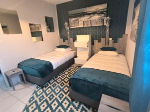 een slaapkamer met 2 bedden en een tapijt bij La Parenthèse colorée in Châteaumur