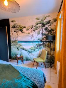 een slaapkamer met een schilderij aan de muur bij La Parenthèse colorée in Châteaumur