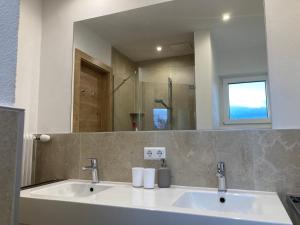 een badkamer met een wastafel en een spiegel bij Haus Werner in Ramsau am Dachstein +32 foto's