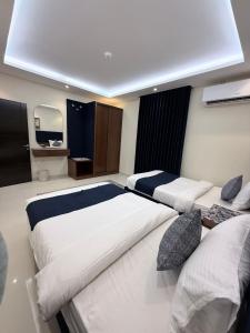 a bedroom with two beds and a mirror at اختيار السائح للشقق المخدومة in Jazan