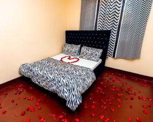 a bedroom with a bed with red petals on the floor at Mango Hostel Arusha in Arusha +8 photos