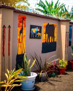 a building with paintings on the side of it with plants at Mango Hostel Arusha in Arusha