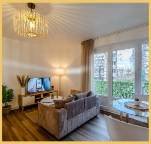 een woonkamer met een bank en een tafel bij Little cocoon I Studio I Annemasse in Annemasse