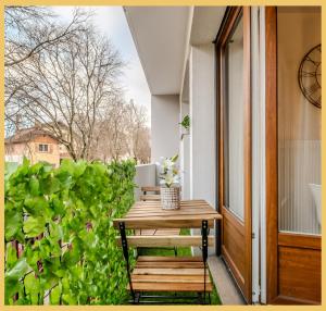 een houten bank op een veranda naast een raam bij Little cocoon I Studio I Annemasse in Annemasse