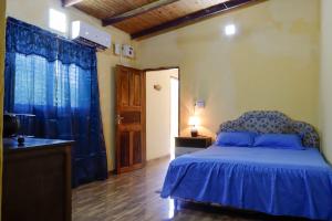 a bedroom with a blue bed and a sink at Ulises House in Luque