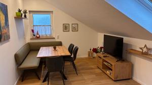 a dining room with a table and a television at Schneekopfblick in Oberhof