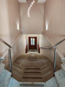 a hallway with stairs with a door and a chandelier at KONDOR apartmani in Vrnjačka Banja +34 photos