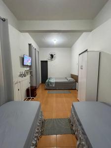 a room with two beds and a tv in it at Hotel Colombo in São Lourenço