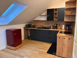 a kitchen with black cabinets and a red refrigerator at Schneekopfblick in Oberhof