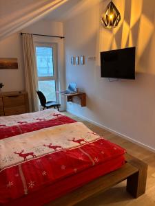 a bedroom with a bed and a tv on the wall at Schneekopfblick in Oberhof