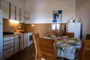 a kitchen with a table with chairs and a refrigerator at House Marija in Primošten