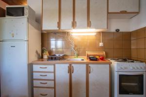 a kitchen with a white refrigerator and a sink at House Marija in Primošten