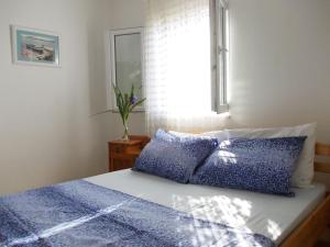 a bedroom with a bed with blue sheets and a window at House Marija in Primošten +40 photos