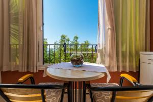 a table and chairs in a room with a window at Apartments Kunac in Podgora