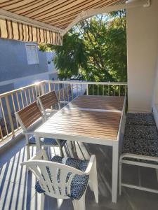 a deck with a table and chairs on a balcony at sol y arena in Santa Pola