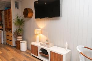 a living room with a tv on a wall at Cozy studio, beach and pool access with sea view in Marigot