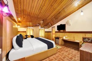 a bedroom with a bed and a desk and a television at Hotel O Hilton Resorts and Spa in Baragrān