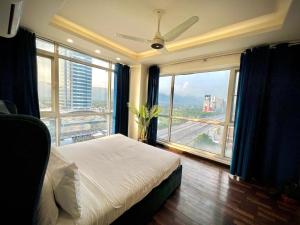 拉合尔Gold Crest Prime Heights Executive Apartments-DHA Lahore的一间卧室，里面有一张床和一扇大窗户。