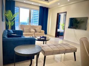 拉合尔Gold Crest Prime Heights Executive Apartments-DHA Lahore的客厅里有一张蓝色的沙发和一张桌子