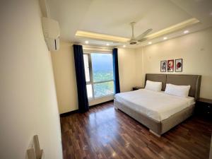 拉合尔Gold Crest Prime Heights Executive Apartments-DHA Lahore的一间卧室，里面有一张床和一扇大窗户。