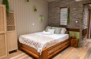 a bed in a room with a brick wall at Cozy studio, beach and pool access with sea view in Marigot