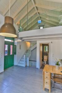 a large room with a staircase and a green door at Annika Deluxe Apartments in Symi