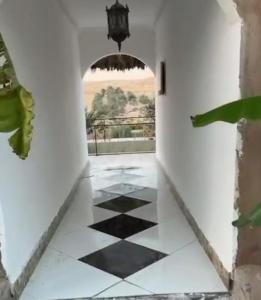 a hallway with a black and white checkered floor at شاليهات ليوا in Al Mashrūb