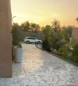 a white car is parked on a driveway at شاليهات ليوا in Al Mashrūb