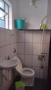 a bathroom with a toilet and a sink at Seu lar na Praia, Condomínio Vila Gustavo-excelente localização in Caraguatatuba