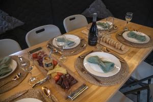 a wooden table with plates of food and wine glasses at Yellow Plum Camp Pehoé in Torres del Paine