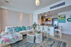 a living room with a couch and a kitchen at Las Olas, Juan Dolio 2bed2bath Condo in Guayacanes