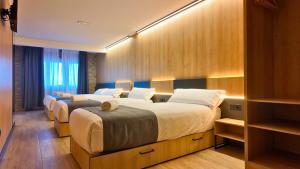 twee bedden in een hotelkamer met verlichting bij Hotel Catanies in Pas de la Casa