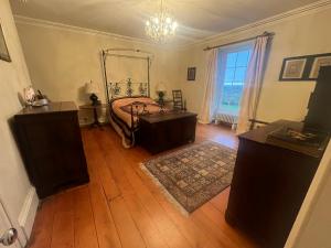 una camera con letto, pavimenti in legno e finestra di Castellmai a Caernarfon