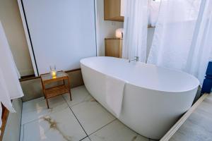 eine weiße Badewanne im Bad mit einem Tisch in der Unterkunft The Amsterdam Houseboat Family - de Jordaan Brand New Houseboat! in Amsterdam + 57 Fotos