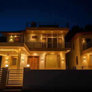 Shail by Shubhs في Bhowāli: منزل كبير مع أضواء على جانبه في الليل