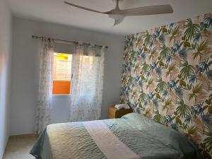 Casa Caletillas في كانديلاريا: غرفة نوم بسرير وورق جدران استوائي