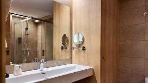 een badkamer met een wastafel en een spiegel bij Hotel Catanies in Pas de la Casa