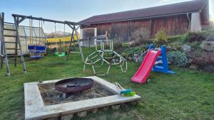 a backyard with a fire pit and a playground at Ferienhof Krug in Wiggensbach