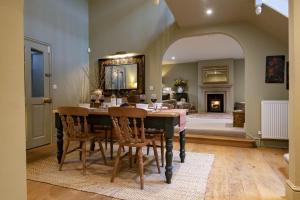 a dining room with a table and chairs and a fireplace at Lark Rise in Boltby
