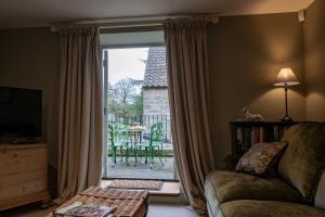 a living room with a couch and a sliding glass door at Lark Rise in Boltby