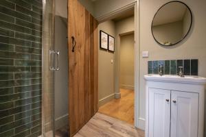 a bathroom with a shower and a sink and a mirror at Lark Rise in Boltby +36 photos
