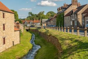 a river in a village with houses at Lark Rise in Boltby