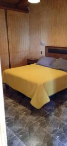- une chambre avec un grand lit jaune dans l'établissement Gran cabaña en playas ILoca, Curico, à Licantén