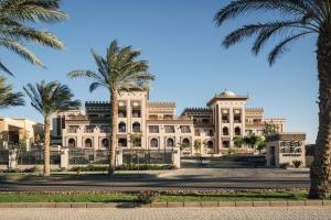 Al Kasr Sahl Hasheesh في الغردقة: مبنى كبير أمامه أشجار النخيل