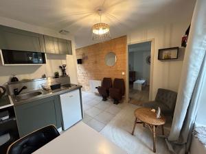 een keuken en een woonkamer met een tafel bij L'annexe in Venouse