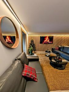 een woonkamer met een bank en een spiegel bij Hotel Catanies in Pas de la Casa