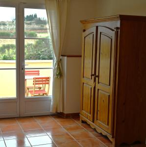 a room with a cabinet and a sliding glass door at Les Mourguettes in La Celle-sous-Gouzon