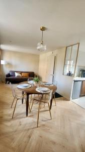 Les Roses - Appartement cosy proche plage - Veules-les-Roses في فول-لي-روز: غرفة معيشة مع طاولة وكراسي وأريكة